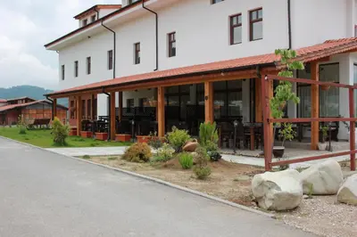 a large white building with windows and rocks at Hotel Podkovata in Etropole