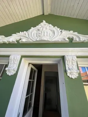 a white trim above a door on a green building at Serdika Old City House in Sofia
