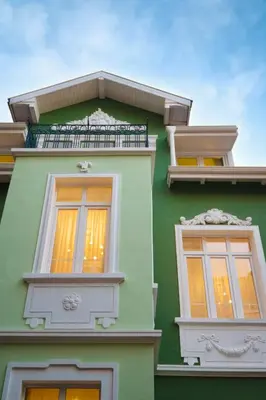 a green building with two windows and a balcony at Serdika Old City House in Sofia