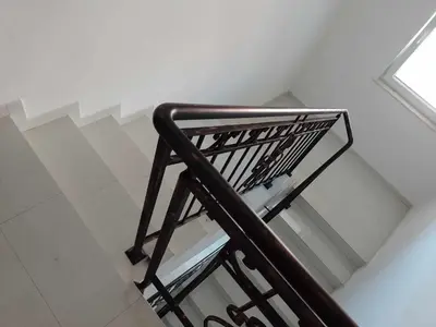 a staircase with a metal railing in a room at Цвят бяло in Sofia