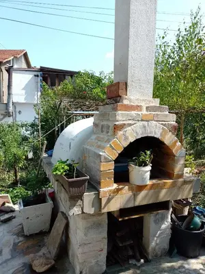 a brick oven with two potted plants on it at Цвят бяло in Sofia