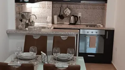 a kitchen with a table with wine glasses on it at Serenity Apt Iztok Sofia in Sofia