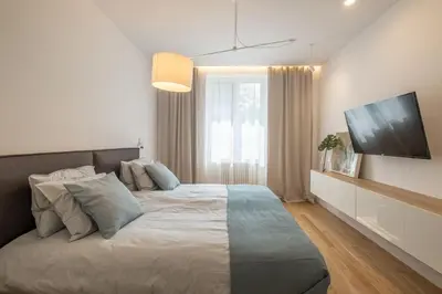 a bedroom with a large bed and a flat screen tv at Top-Notch location, an Exceptionally Stylish flat in Sofia