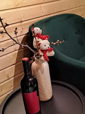 a bottle of wine and a vase witheddy bears on a table at Saint Constantine Mountain Retreat in Peshtera