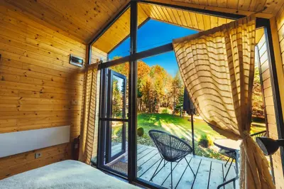 a bedroom with a large window and a patio at Saint Constantine Mountain Retreat in Peshtera