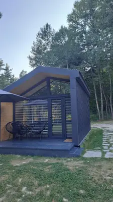 a shed with a table and two chairs in the grass at Saint Constantine Mountain Retreat in Peshtera