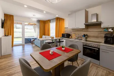 a kitchen and living room with a table and chairs at Villa Nikol Apt #2 in Raduil