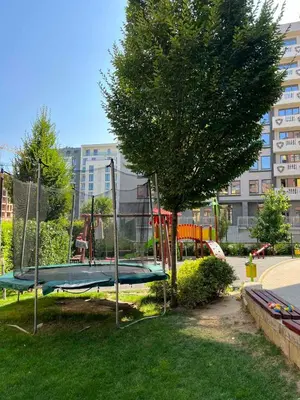 a playground with a tree and a trampoline at Johannesburg 2BDR Spacious Family apt w Parking and Playground in Sofia