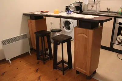 a kitchen counter with two stools and a washing machine at Apartment in Forest Glade Hotel in Pamporovo