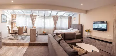 a living room with a couch and a bed at Cityscape Luxury Suites in Plovdiv