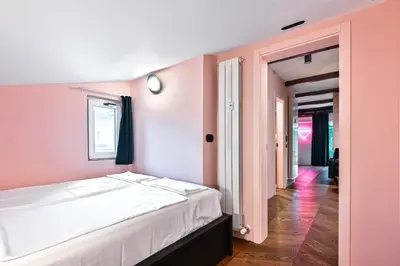 a bedroom with a white bed and a pink wall at Lozenetz Gem Cozy 1-Bedroom Apartment in Sofia by Flat Mаnager in Sofia