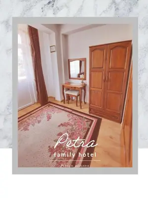 a living room with a wooden cabinet and a rug at Petra Hotel in Petrich