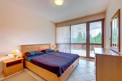 a bedroom with a bed and a large window at Panorama Studio in Stoykite