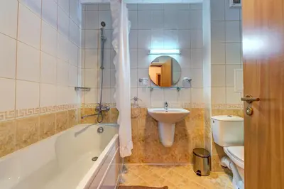 a bathroom with a tub and a sink and a toilet at Panorama Studio in Stoykite