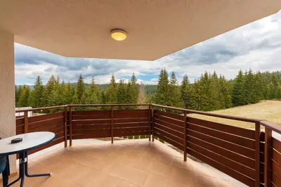 a balcony with a table and a view of trees at Panorama Studio in Stoykite