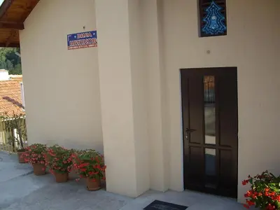 a building with potted plants in front of a door at Villa Shipkovo in Shipkovo