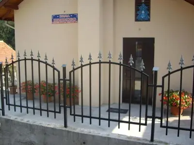 a fence in front of a building with flowers at Villa Shipkovo in Shipkovo