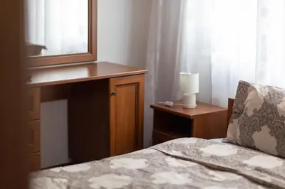 a bedroom with a bed and a mirror and a lamp at Karastoyanovi's apartment 3 in Sofia