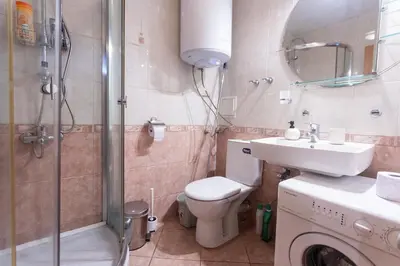 a bathroom with a toilet and a sink and a shower at Karastoyanovi's apartment 3 in Sofia