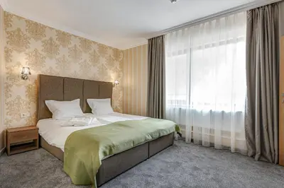 a bedroom with a large bed and a window at Къща за гости Чудните Мостове in Zabŭrdo