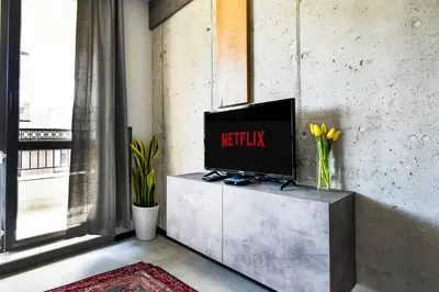 a television on a cabinet in a room with a window at 6 Studios 6 Bathrooms 2 Levels Kitchens in Sofia