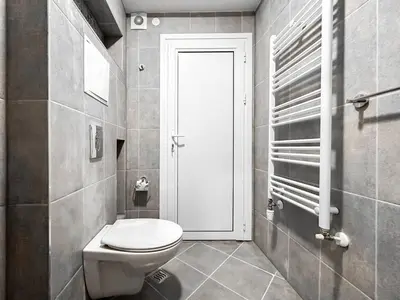a bathroom with a white toilet and a door at 6 Studios 6 Bathrooms 2 Levels Kitchens in Sofia