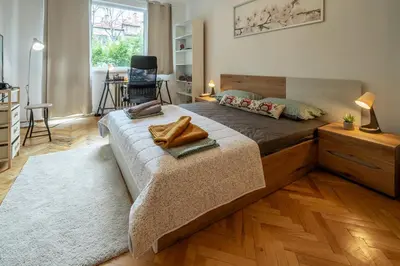 a bedroom with a large bed with a wooden floor at Vivid Condo by NDK and Vitosha Blvd with Free Secured Parking and AC in Sofia