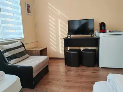 a living room with a tv and a couch and a chair at стаи за гости TODA in Troyan
