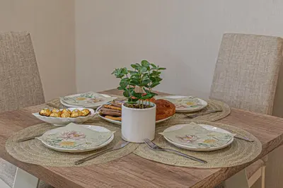 a wooden table with plates and a potted plant on it at Cappuccino Dream in Sofia