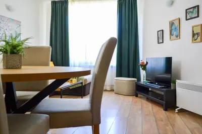 a living room with a table and a television at Forest view in Pamporovo
