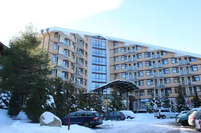a large building with cars parked in the snow at Spacious studio sleeps 4 in Flora main building 706A in Borovets
