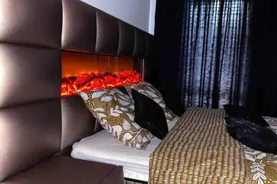 a bedroom with a bed with a headboard and pillows at Cosy Appartement Green Life Bansko in Bansko
