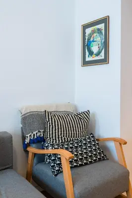 a living room with a chair and a picture on the wall at Colorful Getaway right next to NDK by Flat Mаnager in Sofia