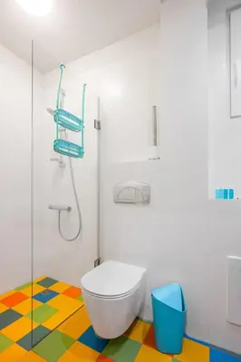 a bathroom with a toilet and a colorful floor at Colorful Getaway right next to NDK by Flat Mаnager in Sofia