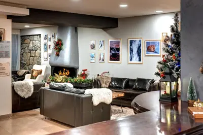 a living room with a couch and a fireplace at Hotel Panorama Ski in Pamporovo