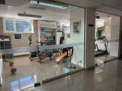 a gym with a mirror and some exercise equipment at Hotel Panorama Ski in Pamporovo