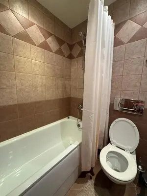 a bathroom with a toilet and a bath tub with a shower curtain at Studio Royal Plaza sleeps 4 Prime location, distance to ski lift - 50M in Borovets