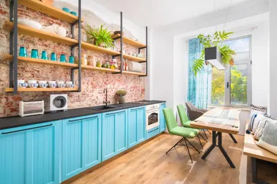 a kitchen with blue cabinets and a table with chairs at Alexandra's City Center Apartment II in Sofia