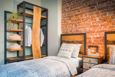 a bedroom with two beds and a brick wall at Alexandra's City Center Apartment II in Sofia