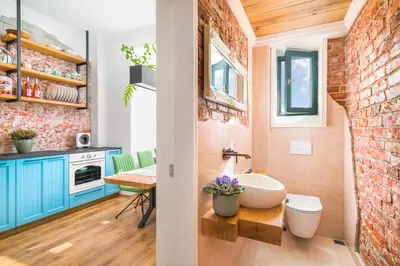 a bathroom with a sink and a brick wall at Alexandra's City Center Apartment II in Sofia