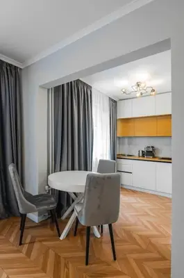 a dining room with a table and chairs and a kitchen at Lozenets Apartment in Sofia