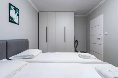 a white bedroom with a bed and white cabinets at Lozenets Apartment in Sofia