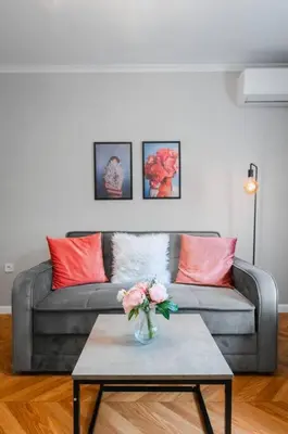 a living room with a couch and a table with flowers at Lozenets Apartment in Sofia