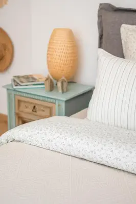a bed with a pillow and a table with a lamp at Alexandra's City Center Apartment III in Sofia