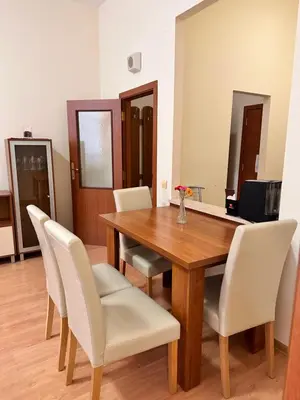 a dining room with a wooden table and white chairs at Stylish one bedroomed apartment 112 in main Flora building in Borovets