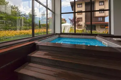 a swimming pool in a house with a window at Pirin Bliss Apartment Ski, Spa and Relax at Terra Complex in Razlog