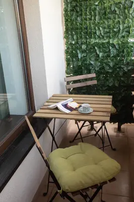 a table and chair next to a table and a window at Pirin Bliss Apartment Ski, Spa and Relax at Terra Complex in Razlog
