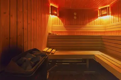 a sauna with a bench and a tub in it at Pirin Bliss Apartment Ski, Spa and Relax at Terra Complex in Razlog