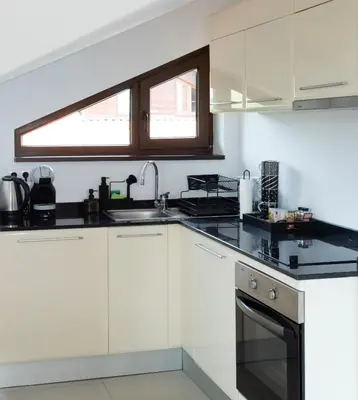 a kitchen with white cabinets and a sink and a window at Pirin Bliss Apartment Ski, Spa and Relax at Terra Complex in Razlog