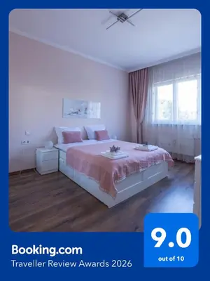 a white bedroom with a bed with pink sheets at Julie Suite Top Center in Sofia